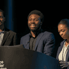 Students give a presentation on the stage in an auditorium. 