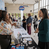 People enjoy exhibit tables, lunch, and a band at an employee event.