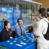 People enjoy exhibit tables, lunch, and a band at an employee event.