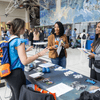 People enjoy exhibit tables, lunch, and a band at an employee event.