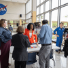 People enjoy exhibit tables, lunch, and a band at an employee event.