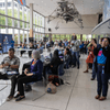 People enjoy exhibit tables, lunch, and a band at an employee event.