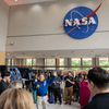 A crowd of people outside or in a lobby celebrating the 2024 eclipse in Texas. 