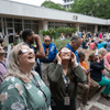 A crowd of people outside or in a lobby celebrating the 2024 eclipse in Texas. 