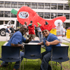 A group of people gather outside for a chili cook-off.