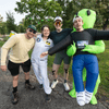 A group of people dressed in costumes outside during a race event.