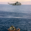 Apollo 10 astronauts are helped out of the Command Module by Navy recovery swimmers while a helicopter hovers ready to hoist them aboard. Image Credit: NASA