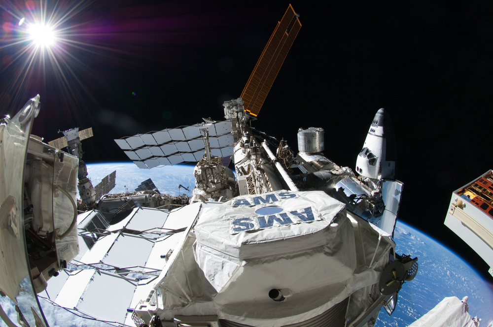 External view of the solar panels and modules on the International Space Station with a space shuttle attached.