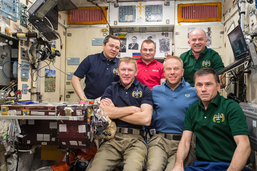 Expedition 47 crew poses for the 3 millionth image taken aboard the International Space Station.