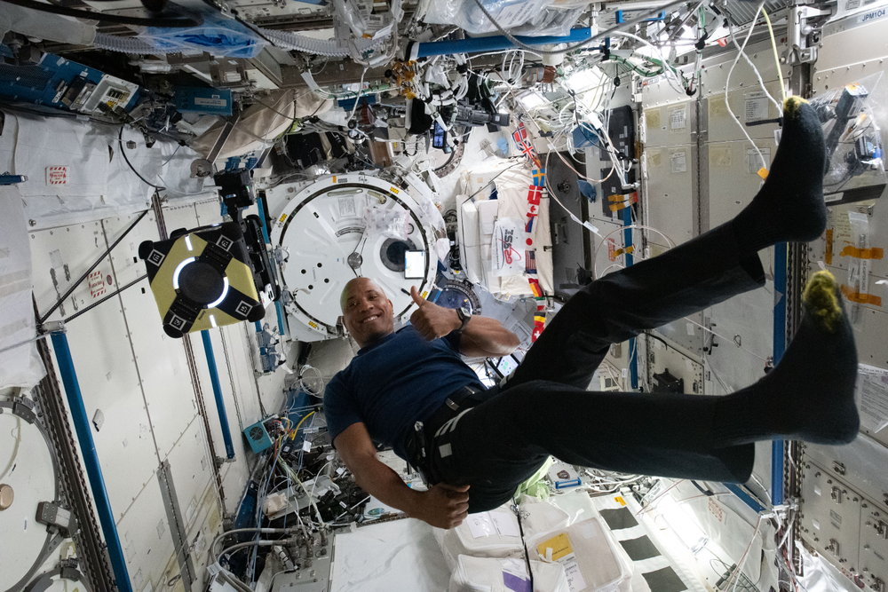 View of NASA astronaut Victor Glover in Kibo, the Japanese Experiment Module (JEM) conducting work on the Astrobee, Honey. In the background, the JEM airlock can be seen as well. Credit: Japan Aerospace Exploration Agency (JAXA)/Soichi Noguchi