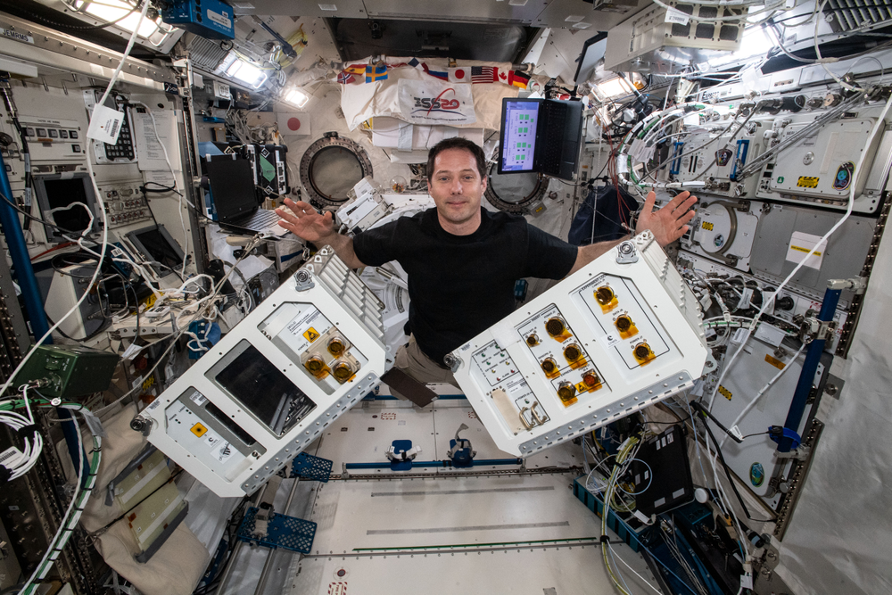 Expedition 65 Commander Thomas Pesquet of ESA (European Space Agency) gathers fluid, physics, and materials research hardware inside the International Space Station's Kibo laboratory module. Credits: ESA/Thomas Pesquet
