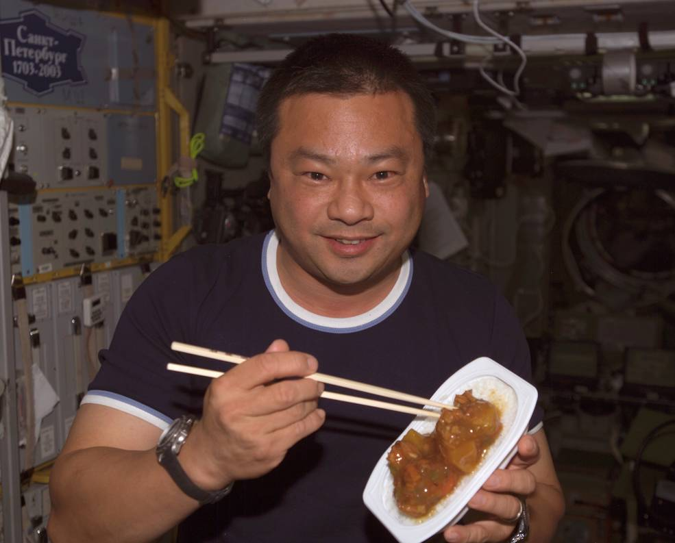 Expedition 10 Commander Leroy Chiao enjoying a Chinese-inspired dish.