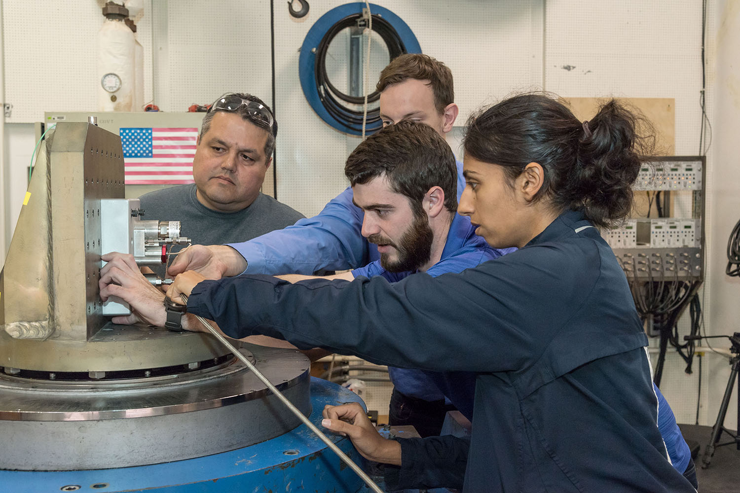 From right to left: Pooja Desai, Matt Atwell, and Chris Radke behind Atwell of the Seeker team working on the high pressure system with a technician from JSC’s Energy System Testing Area (ESTA).