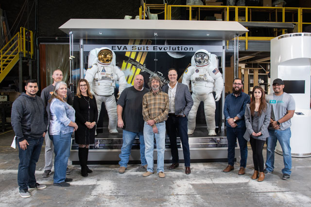 The Exhibits team stands with the new EVA Suit Evolution exhibit that will educate and inspire visitors at Hobby Airport. Image Credit: NASA/James Blair