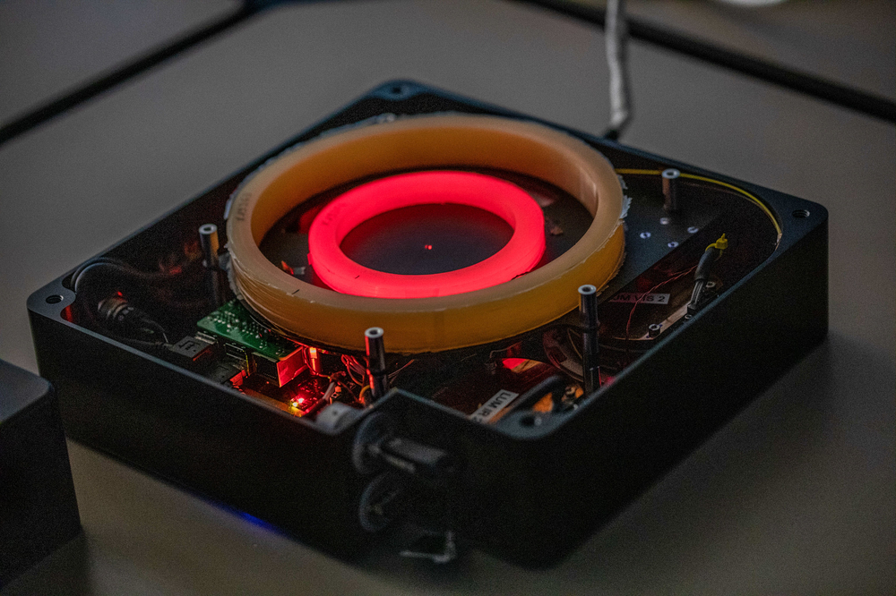 An uncovered electronic device with a yellow circle and a lighted red circle in the middle.