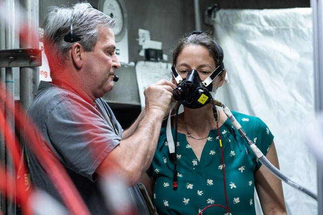 A Crew and Thermal Systems Division test team member at Johnson assists Kate Suratt with mask fit prior to the Exploration Atmosphere Prebreathe Validation study in June 2022.