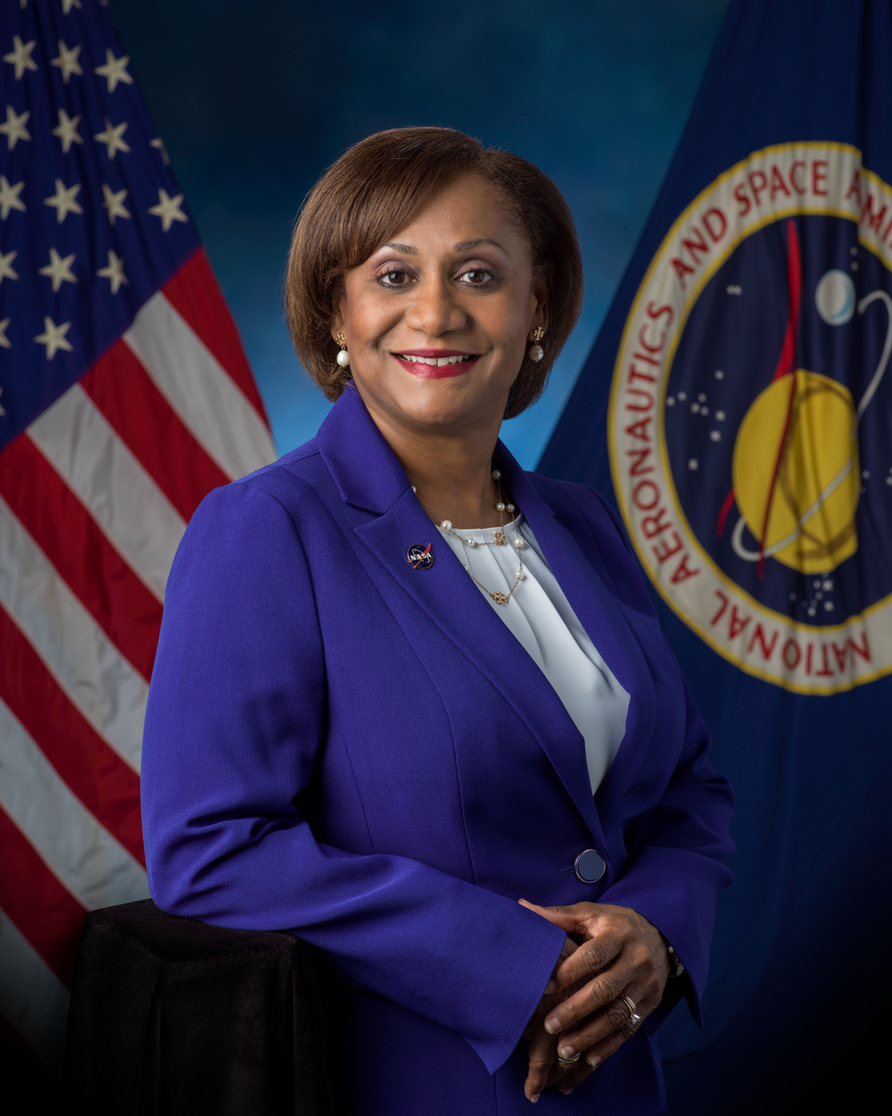 Professional portrait of a short-haired Black woman wearing a royal blue blazer and a white blouse.