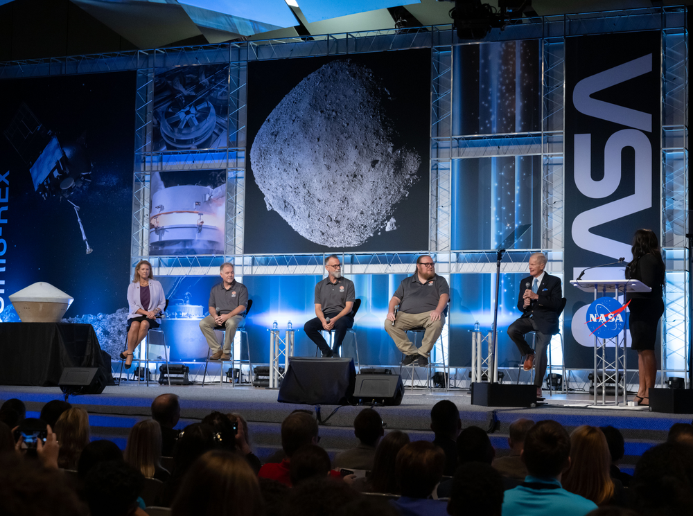 NASA Administrator Bill Nelson and Johnson Space Center researchers present images of the OSIRIS-REx sample on a stage during a public event.