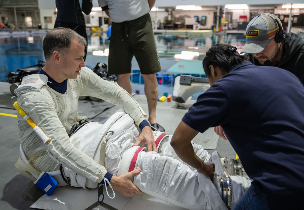 NASA astronaut Nick Hague puts on a spacesuit as he prepares for spacewalk training in a giant swimming pool.