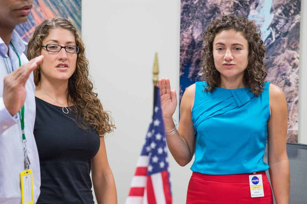 Christina Hammock (left) and Jessica Meir receive their swearing in as NASA employees at the Johnson Space Center on Aug. 12, 2013. The two represent one-fourth of the 2013 class of astronaut candidates.