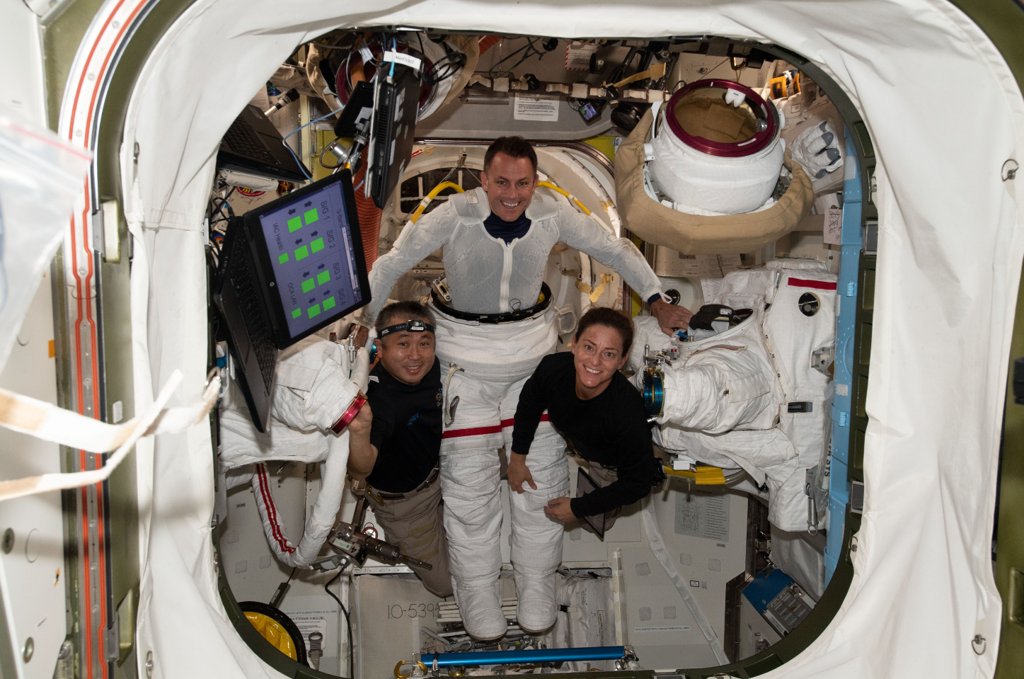 NASA astronaut Josh Cassada (center) is pictured trying on an Extravehicular Mobility Unit, or spacesuit, with assistance from astronaut Koichi Wakata (left) of the Japan Aerospace Exploration Agency and NASA astronaut Nicole Mann (right) inside the International Space Station's Quest airlock. Credits: NASA/Josh Cassada