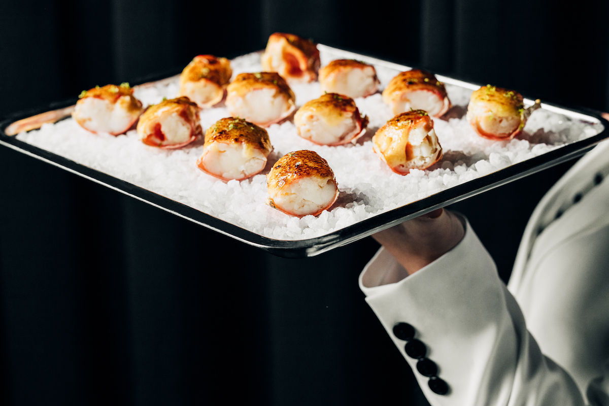 Coal Roasted King Crab on a bed of rock salt on a silver tray.