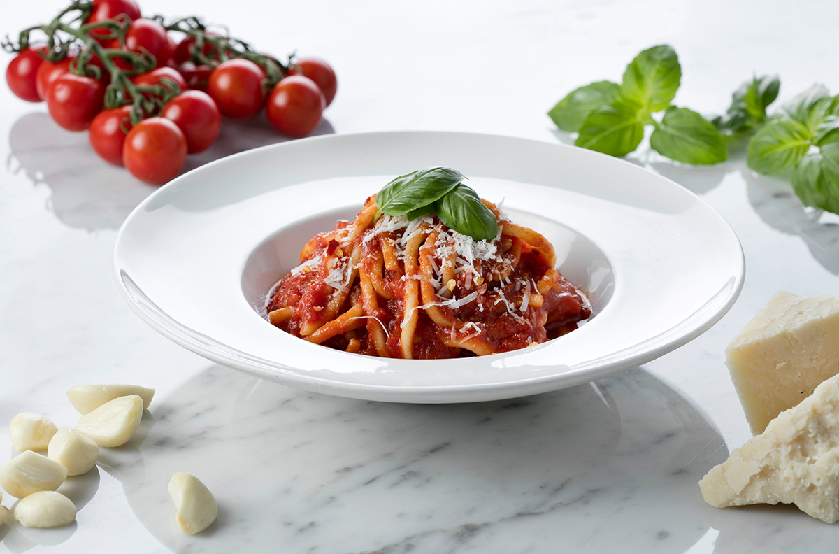 pasta in pomodoro sauce with ingredients around it