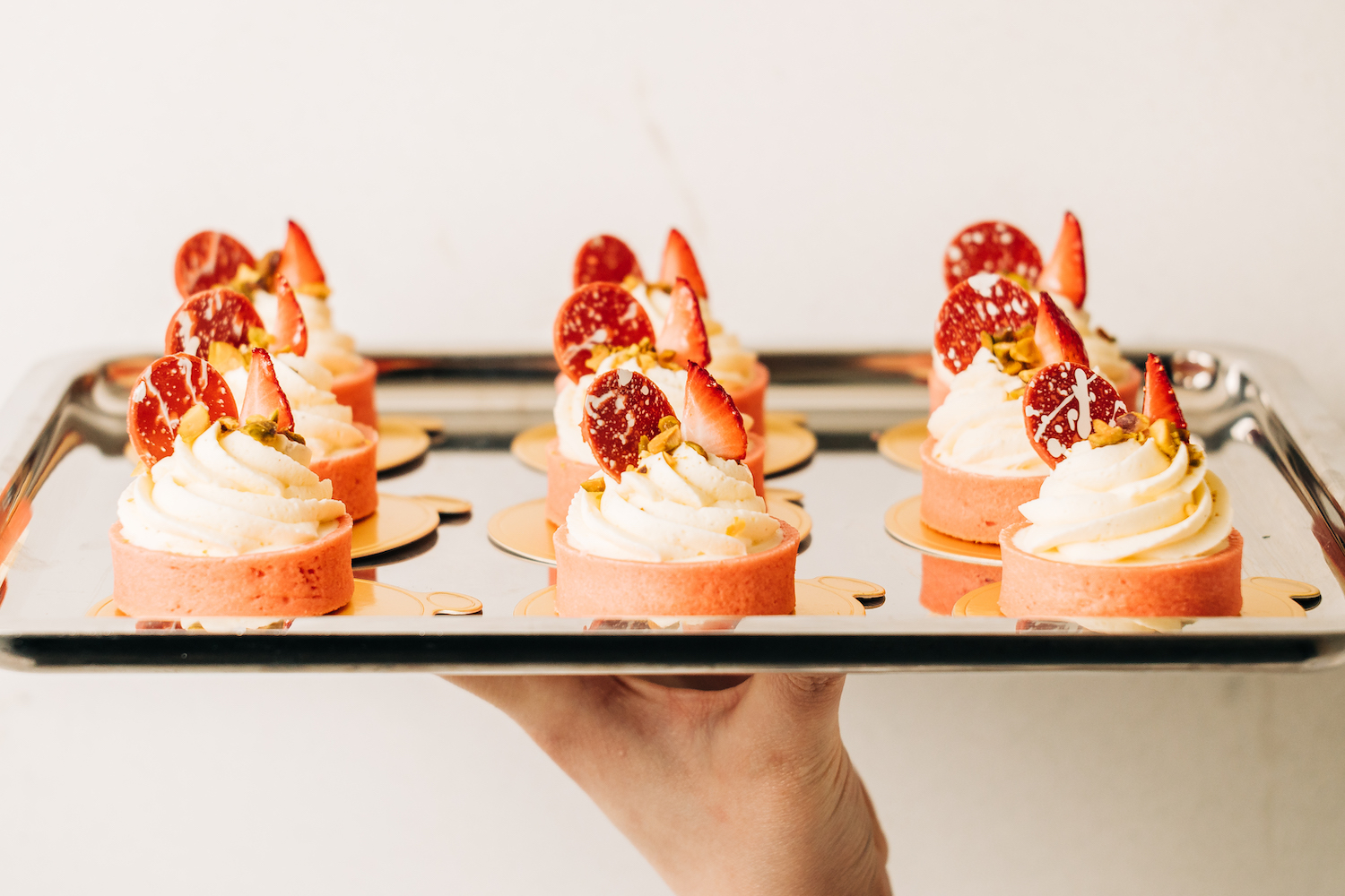 Tray of mini Strawberries and Cream Tart garnished with strawberries and mixed nuts 