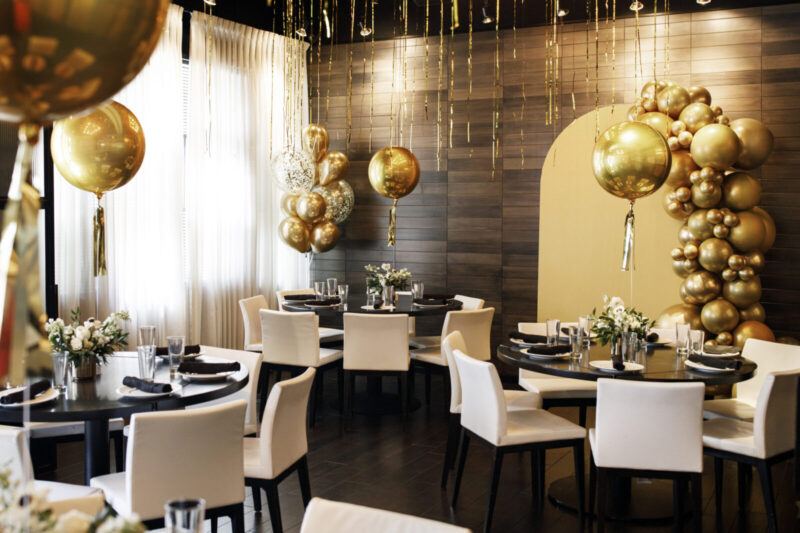 Private dining room decorated with gold balloons.