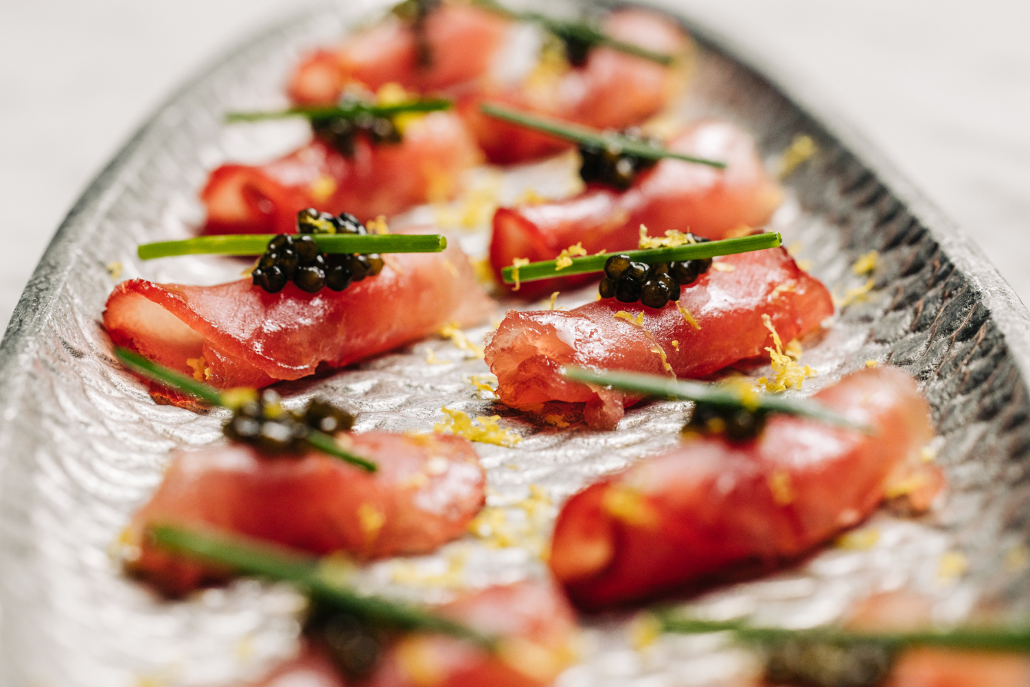 Tray of tuna sashimi with caviar on top. 