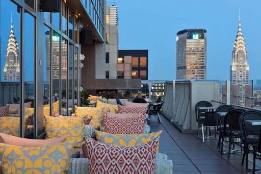 Bar 54 is the tallest rooftop bar in Times Square!
And also among the highest in the city.
Located at the Hyatt Centric Times Square, Bar 54 offers a really superb river-to-river view, including the Chrysler Building and all of lower Manhattan. The bar serves an impressive drink menu, including a large set of well crafted cocktails, beers, wines in both glass and by bottle, a wide section of whiskey and also some tasty bar bites. The rooftop is open year-round, thanks to a chic and intimate indoor space.