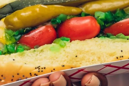 Where To Eat Hot Dogs In NYC?
Plentiful, relatively cheap, and easy to eat as you jaywalk or wait for a bus, hot dogs are an essential part of New York City cuisine.
And Chicago Dogs are officially part of New York City’s hot dog ecosystem, and the ones at Dog Day Afternoon in Windsor Terrace are some of the best.
This kitschy little shop keeps a Vienna Beef diagram next to the register, so you can cross-check your dog and make sure it matches up. The poppyseed bun is especially soft and flavorful, and the combination of a Chicago dog with an orange whip on the sidewalk outside the restaurant is one of our favorite meals on a warm day.