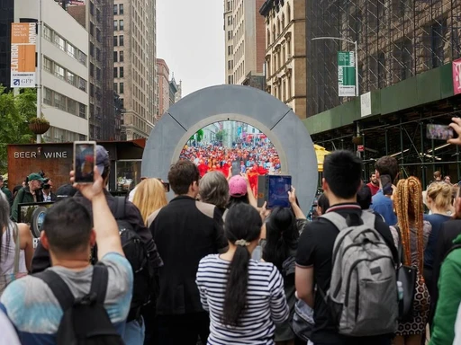 The Portal is New York City’s hottest talking point right now, and the installation in Flatiron virtually connects NYC to Dublin in real time!
The Portal connects two vibrant cities in real time, making for an engaging experience for both New Yorkers and visitors and fostering a sense of connection across the Atlantic.
Founded by Lithuanian artist and entrepreneur Benediktas Gylys, portals are an invitation to meet fellow humans around the world and, in turn, feel united and one. The sculpture’s livestream provides a window between far away locations, allowing people to meet others outside of their usual social circle and culture.
The visual live stream connects the two cities, allowing you to meet fellow humans around the world! It’s free to visit and it’s located on the Flatiron South Public Plaza at Broadway, Fifth Avenue, and 23rd Street, next to the Flatiron Building.