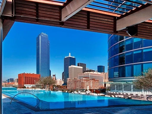 The pool in Omni Dallas Hotel, located in the center of downtown Dallas, offers a year round oasis to all hotel guests.
Take a swim in the heated infinity swimming pool, sip a cocktail by the seasonal fire pit or work on your tan in one of the lounge chairs, all while overlooking downtown Dallas.
During summer months, The Uptown Terrace Pool Bar & Grill and infinity pool is only open to registered guests of the hotel. But during winter months, non-hotel guests can get access with day passes Sunday to Thursday.