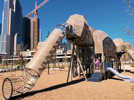 DALLAS HARWOOD multi-use park has so much to offer!
Kids will love the mammoth-themed playground.
There’s also a splash pad for warmer days, a multi-use court, two gravel dog parks, picnic table area, and lots of green space. Community events like movie nights, yoga, and live music are hosted on the stage area!