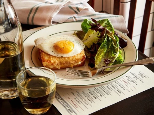 MIAMI’S BEST RESTAURANT WITH “AMBIENTE”
Where the vibe is more important but the food is still good
The iconic NYC staple, Pastis, expanded its presence from the Meatpacking District to the vibrant neighborhood of Wynwood. The restaurant stays true to its New York roots, offering the same menu filled with classic Parisian bistro-style dishes and an incredible ambiance that won’t make you feel like you’re in Miami.
You’re heading here for a chic lunch or dinner and sitting at their gorgeous outdoor patio decorated with ceiling fans, red patio umbrellas, and twinkly lights. We’d start with some drinks (of course), if you’re a spritz person looking to relax, start your meal with their St. Tropez Spritz made with St. Germain, lemon, aperitif, sparkling wine, and strawberries. But if you’ve had a long day (or week) then kick off your meal with a tiny Le Petit Pickle martini.
As for the food, we like to start with a few hors d’oeuvres for the table. We usually go for the Tuna Carpaccio with lemon vinaigrette, Escargots with garlic-parsley butter, Onion Soup, and Crispy Artichokes with garlic aioli. Moving on to the entrées we love their Chicken Paillard with almonds and picholine olives, and we always love to get an order of the Moules Frites with white wine and garlic for the table (don’t forget to dip the bread in the sauce). If you still have a little room, the grand finale is the airy Profiteroles, delicately filled with velvety smooth vanilla ice cream, and generously drizzled with warm chocolate sauce.