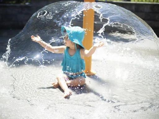 🌟 Pirate Ship-Themed Splash Pad in DFW: Oakridge Park Splash Park 🌟
Why we love it:
❤️ This splash pad is free and open to the public!
❤️ Kids will love the big pirate ship, spray blaster, and multiple slides.
❤️ There’s a texturized surface which makes the ground less slippery (although it’s still a great idea to wear shoes).
❤️ There are some shaded seating areas.
Good to know:
- This splash pad is Open Daily from 9am-7pm through Labor Day.
- This splash pad is probably best for ages 3+ as there were lots of older kids during our visit.
- Go on a weekday morning to avoid a crowd.
- Though there is some shaded seating, there’s not a lot! Plan to bring a towel to sit on in case all of the seats are taken.