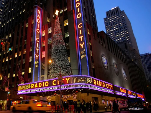 Radio City Music Hall: The Jewel of New York City 🗽🎶
When we think of New York City, we often imagine its towering skyscrapers 🏙️, lush green parks 🌳 and, of course, world-class entertainment venues 🎭. At the heart of it all is Radio City Music Hall, a true Big Apple landmark 🍎.
This Art Deco landmark 🏛️, located in Rockefeller Center, is one of the most famous and beloved theaters in the world. Since its opening in 1932, Radio City Music Hall has hosted countless shows and events, from concerts by music legends 🎤 to performances by the Rockettes, an internationally renowned dance group 💃.
But the real magic happens when the lights go down and the show begins 🌟. Whether you're there for a concert, a musical, or the famous Christmas show, every performance at Radio City Music Hall is an unforgettable experience 🎄.
So on your next visit to New York City, be sure to stop by Radio City Music Hall 📍. Whether it's for a tour or to see a show, it's sure to add a touch of glitz to your stay in the city that never sleeps 🌃.