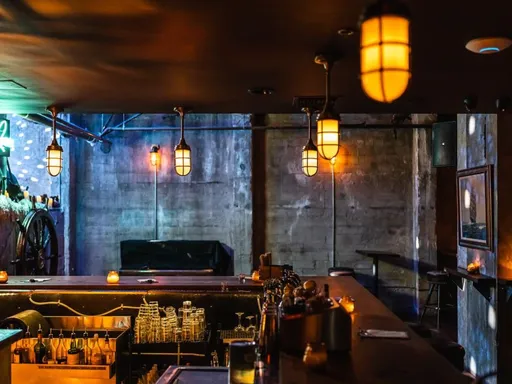 Stowaway
This basement-level piano bar is subtly marked by a small arrow-shaped light at its entrance.
While lacking a traditional stage, the setting boasts a fairly grand ambiance, featuring a curving wood bar, a 7-foot grand piano, and a charmingly kitschy old oil painting portraying a reclining blond burlesque dancer. The menu offers indulgence with its selection of cocktails. Despite its subterranean setting, the venue’s wooden floors and high ceilings create an atmosphere that easily transports guests away from the basement vibe.