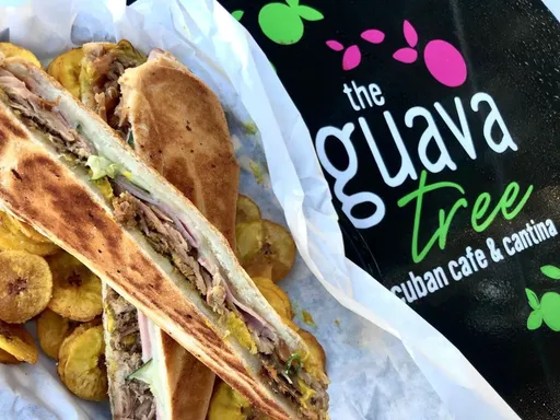 From humble beginnings as a food truck to being featured on Food Network, this place - The Guava Tree - has nailed it!
Every app, drink, and sandwich I’ve tried has been incredibly tasty. Cuban food is packed with flavor, and they’re doing it right here!
There’s so much family history and passion here, from the mural outside to the photos and family working behind the counter, at the cute bar, and in the kitchen.