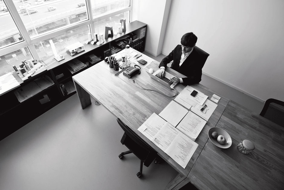 Ole sitting behind his desk, working in his brightly lit office.