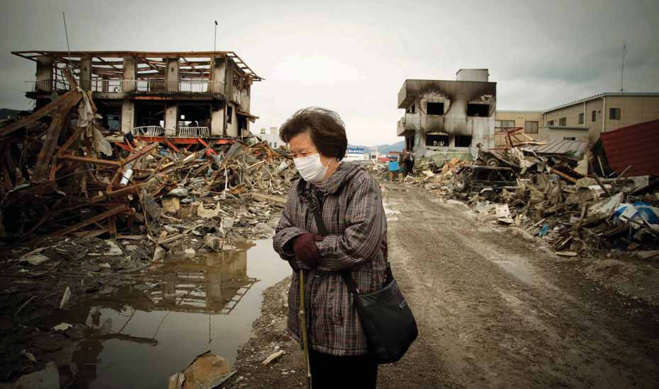 Fukushima, elderly woman surveys the wreckage following the enormous tsnuami that destroyed the coastline