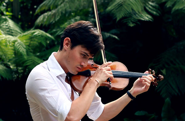 Charlie Siem playing his violin in his garden