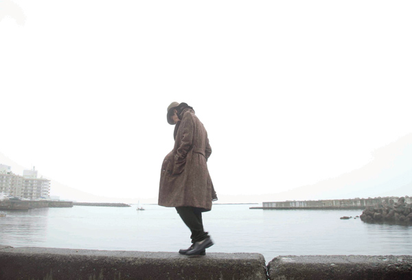 Ryo walking along a sea wall