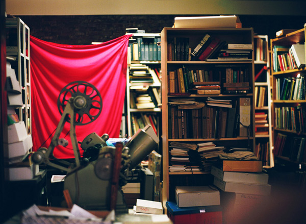 Jonas-Mekas-Studio view - film reels, projector and Archive flag hanging