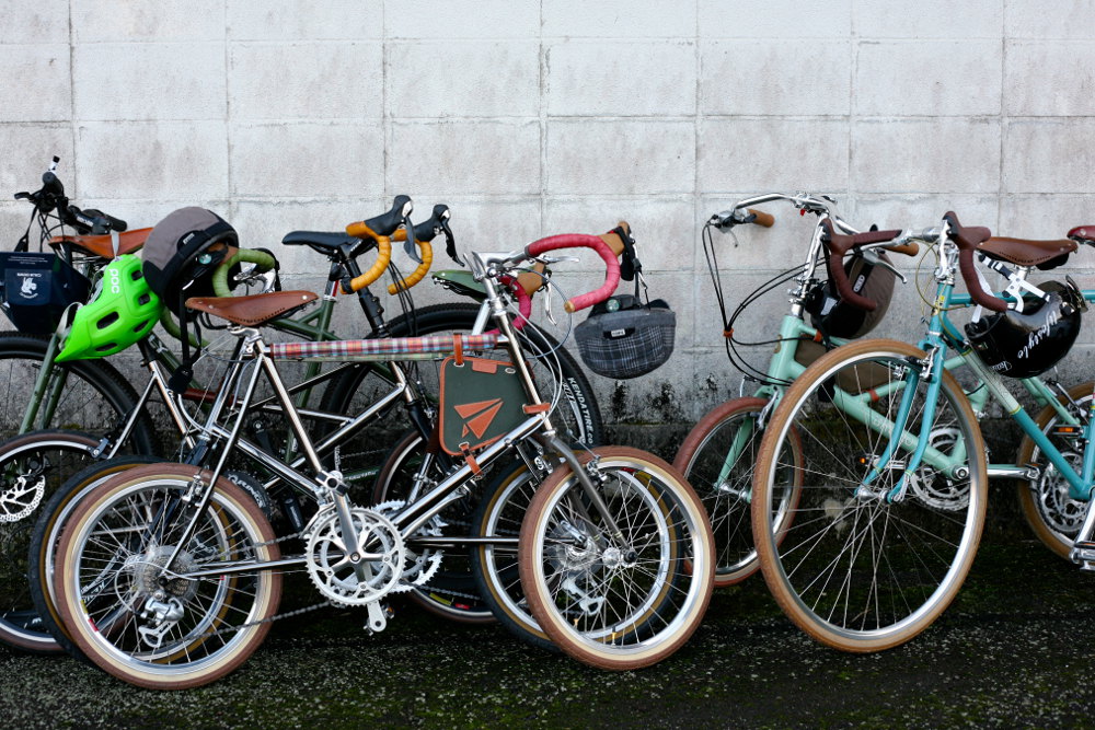 Bikes are parked against a wall while Tour de Nippon riders take a well-earned rest