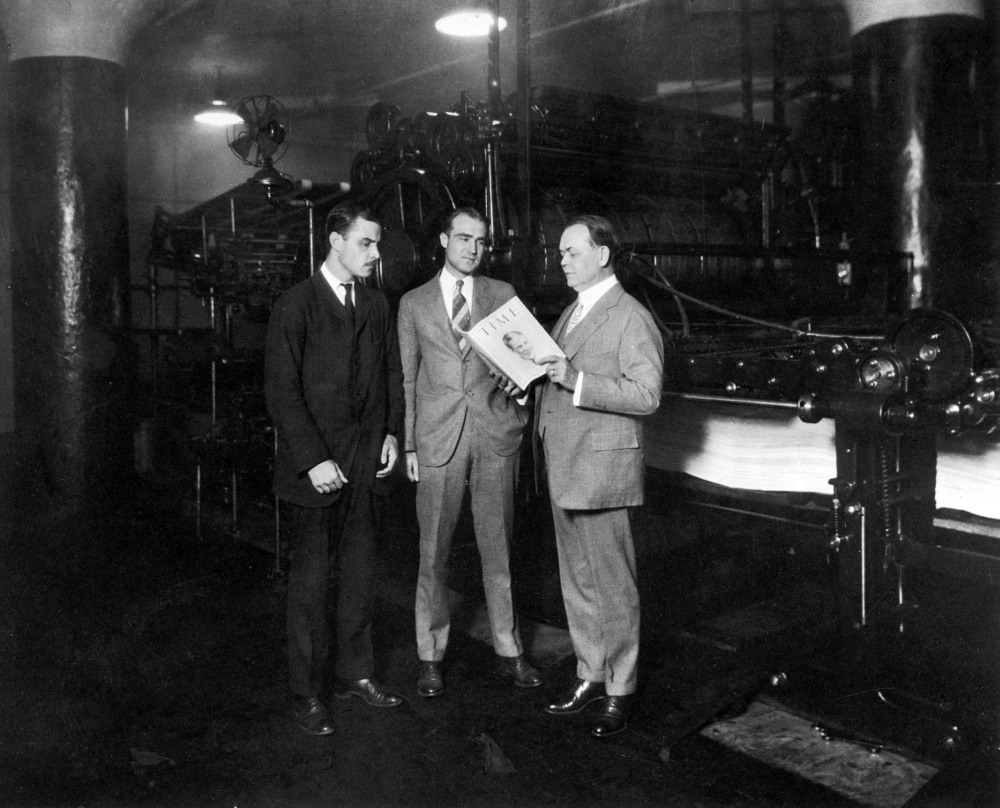 American co-founders of Time magazine Briton Hadden (1898 - 1929) (left) and Henry Luce (1898 - 1967) (centre) stand with politician and Cleveland city manager William R. Hopkins (1869 - 1961) who reads an article from an issue of Time magazine, Cleveland, Ohio, August 31, 1925. The magazine, dated from that day, features golfer Robert Tyre Jones Jr. on the cover. (Photo by Time & Life Pictures/Getty Images)