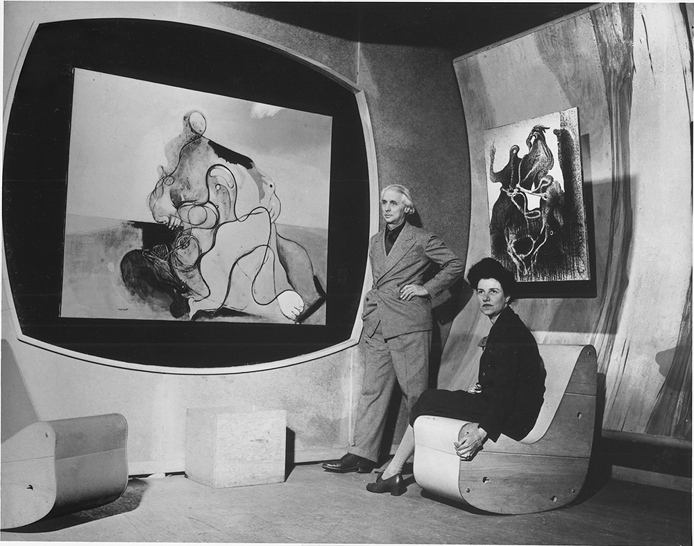 Peggy Guggenheim and Max Ernst in the Surrealist gallery of Art of This Century, New York, 1942 ca. Left to right: Max Ernst, The Kiss (1927, Peggy Guggenheim Collection), and Zoomorphic Couple (1933, Peggy Guggenheim Collection). Courtesy Solomon R. Guggenheim Foundation