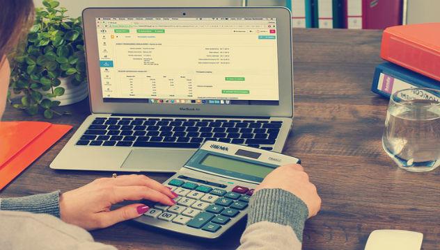 bookkeeper with calculator and laptop