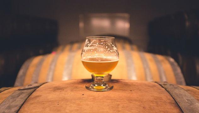 glass of beer on top of cask